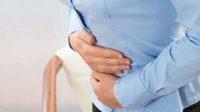 Una mujer se toca el estómago