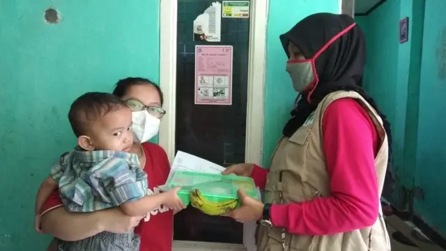 Masyarakat menerima makanan dari program Mozi Masagi.