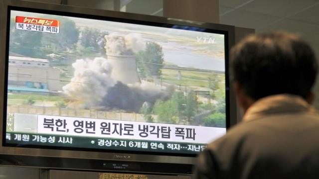 一名韩国人看着销毁朝鲜宁边冷却塔的录像