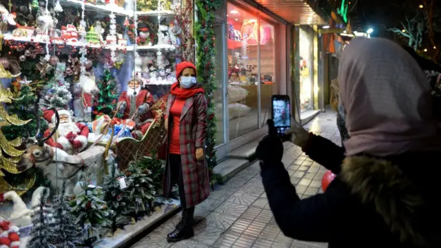 تہران کے ایک مسیحی آبادی والے علاقے میں ایک خاتون کرسمس تھیم اشیا سے سجی ایک دکان کے سامنے تصویر کھنچوا رہی ہیں۔
