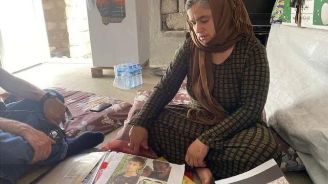 Bahar regarde les photos de son mari et de son fils aîné, qui auraient été tués par l'État islamique.