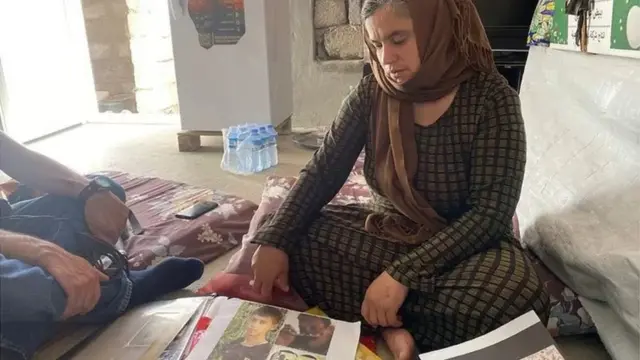 Bahar regarde les photos de son mari et de son fils aîné, qui auraient été tués par l'État islamique.
