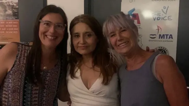 Marjane Beaugeois berdiri di tengah dua kawan.