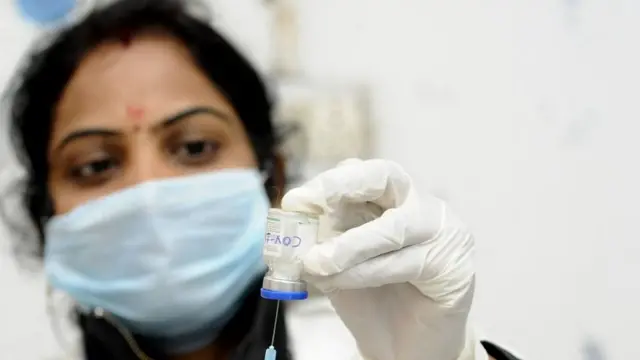 A health worker with vaccine during a trial run in Noida.