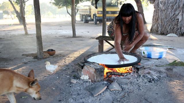 Una indígena cocina un casabe