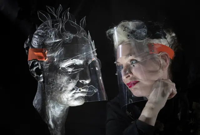 कलाकार बू पेटर्सनले कलात्मक फेस शिल्ड देखाउँदै।