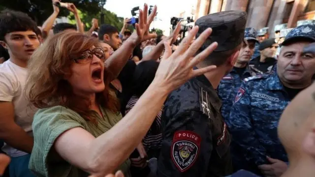 Des manifestants en colère, contenus par des forces de l'ordre