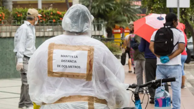 Una persona con un cartel en el que pide que se respete la distancia