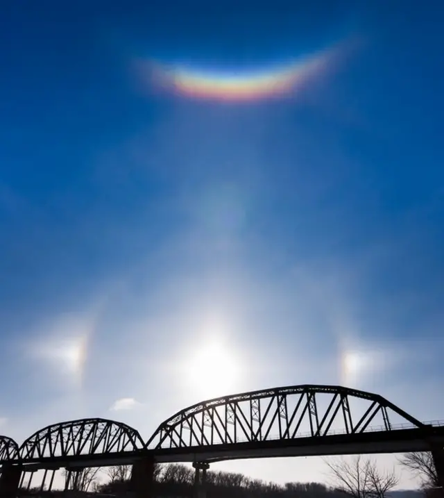 Un arco circuncenital brilla sobre el Sol y sus fantasmas sobre el río Missouri en Nebraska un frío día de enero.