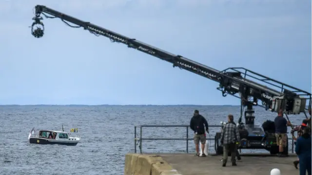 Лодка в море и камера на кране