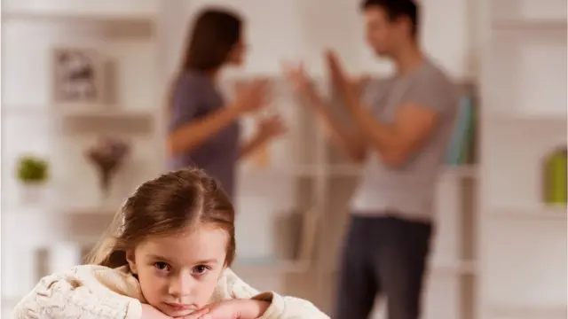 Casal discutindo enquanto menina se aborrece