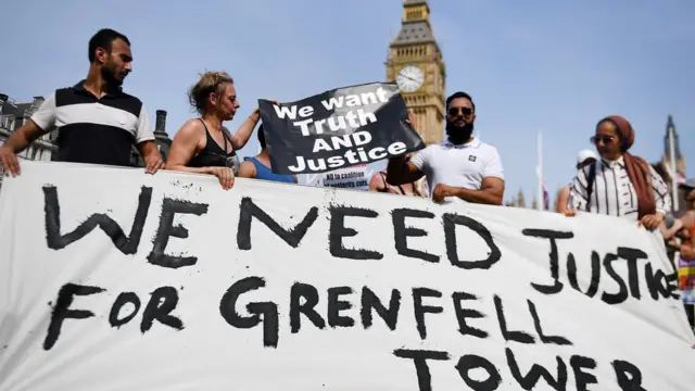 Londra'da yangın sonrası düzenlenen protestolarda "Grenfell Tower için adalet istiyoruz" dövizi tutan göstericiler.