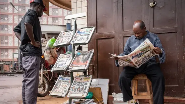 Men dey reading newspapers for one stall for Kampala, Uganda - 15 January 2021