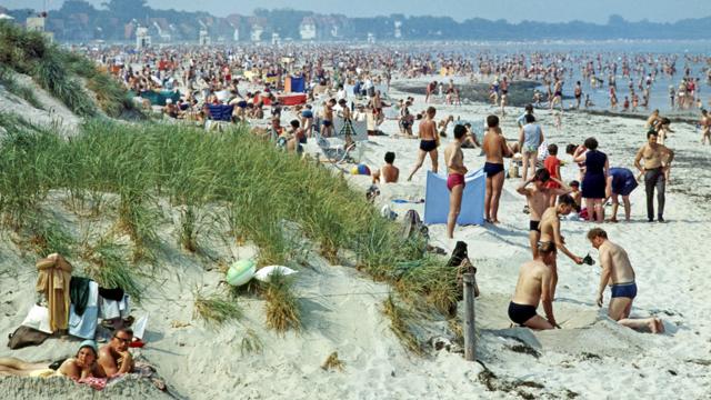 Holiday-makers (members of East Germany's Free German Trade Union Federation) on the beach in Warnemünde on the Baltic Sea (Photo by Harald Lange/ullstein bild via Getty Images) 14 августа 1969