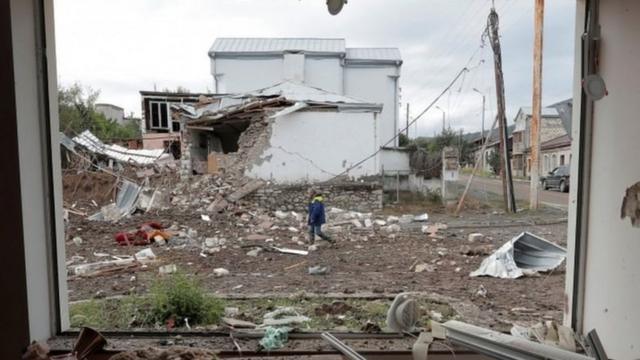 斯捷潘納克特一位居民走過炮戰留下的廢墟（8/10/2020）