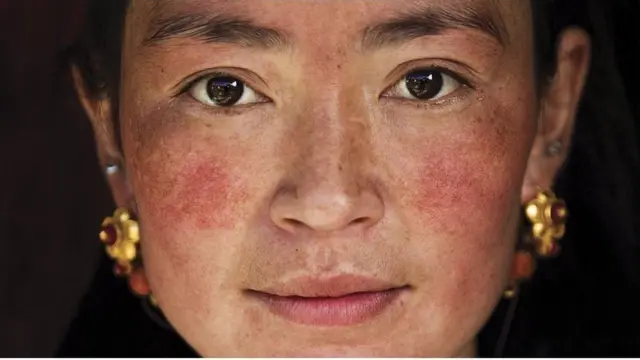 摄影师米哈艾拉在乡村遇到了有两个孩子的藏族母亲。米哈艾拉说，"她当时戴着首饰在打扫房屋"。