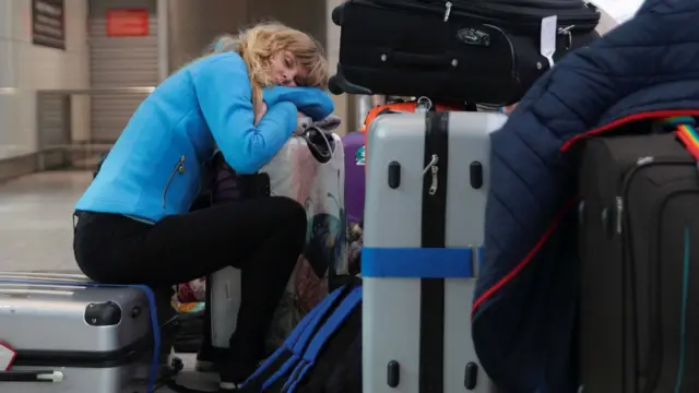 Пассажир, спящий на чемоданах