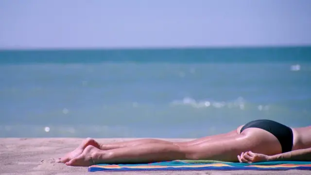 Mujer tomando el sol en una playa