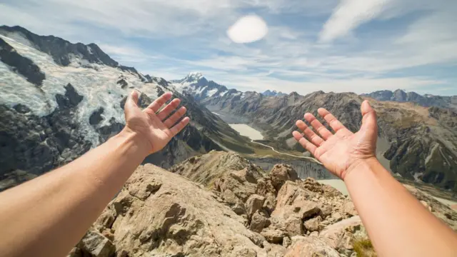 Mãos estendidas na frentesportingbet apkuma paisagem montanhosa