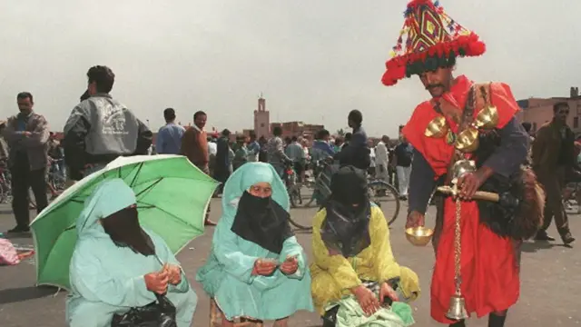 رجل يقدم مشروب لنساء مشاركات في المسيرة الخضراء