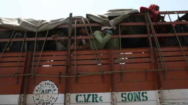 ट्रक में जाते हुए प्रवासी कामगार