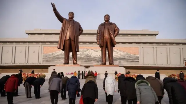 ሰዎች ለቀድሞ የሰሜን ኮሪያ መሪዎች ኪም ኢል-ሱን እና ኪም ጆንግ-ኢል ሃውልቶች አጎንብሰው