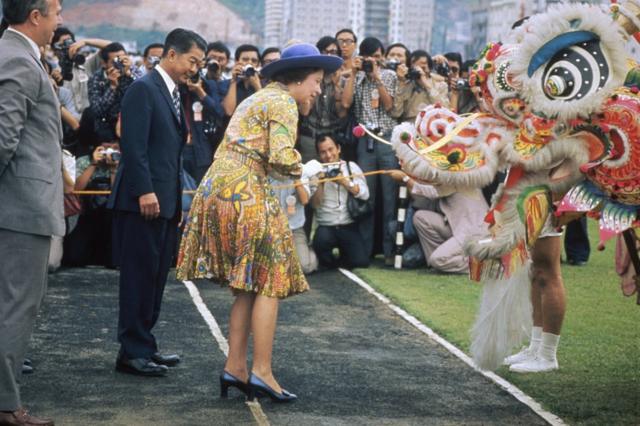 英国女王伊丽莎白二世（中）在香港新界荃湾运动场准备为一头舞狮点睛（6/5/1975）