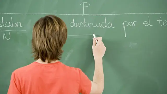 Un hombre de espaldas a un pizarrón