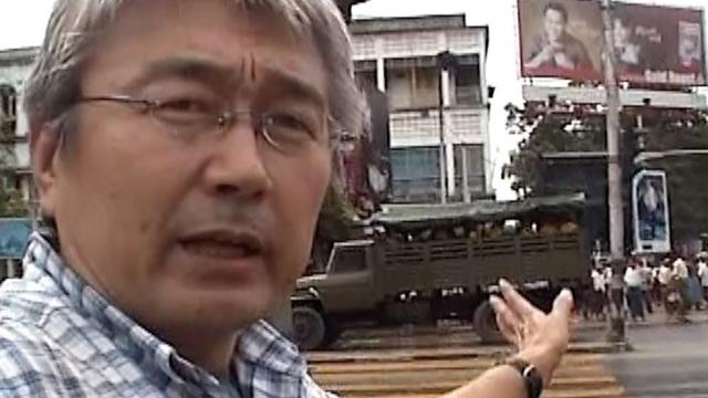 Kenji Nagai in front of Burmese military vehicles