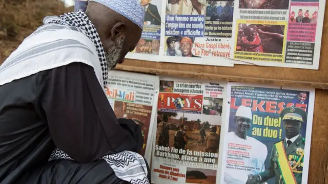 Un homme regarde les gros titres de l'actualité annonçant un retrait majeur de la présence militaire de la France au Sahel, où les forces combattent les insurgés djihadistes depuis huit ans, à Bamako le 11 juin 2021.