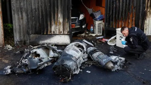 A police officer inspects the remains of a Russian missile shot down by Ukrainian air defence