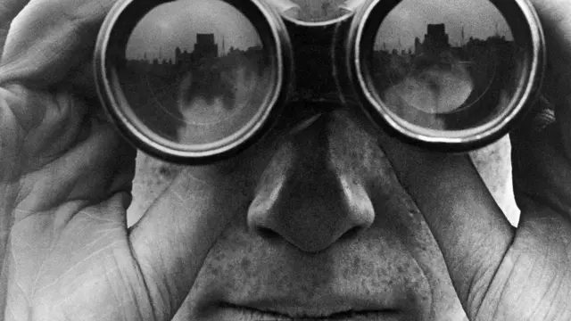 شخص ينظر من خلال عدسات مكبرة