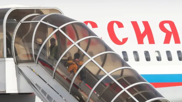 Former Russian embassy staff board a plane at Stansted airport