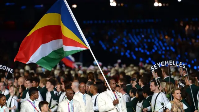 Seychelles Olympic team wey carry di kontri flag.