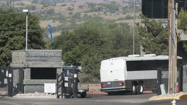 Um ônibus contendo crianças detidas entra nas instalações da US Border Patrol em Nogales, Arizona, 2014