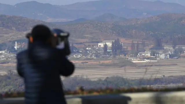 దక్షిణ కొరియా నుంచి బైనాక్యులర్‌లో ఉత్తర కొరియాను వీక్షిస్తున్న ఓ మహిళ