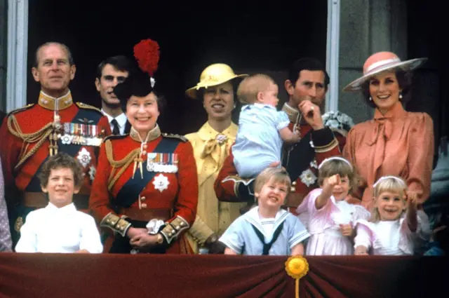 O Príncipe de Gales com a Princesa de Gales, o bebê Príncipe Harry, o Príncipe William, o Duque de Edimburgo, o Príncipe Eduardo, a Rainha Elizabeth II e a Princesa Anne na varanda do Palácio de Buckingham, em Londres, para ver os aviões passarem