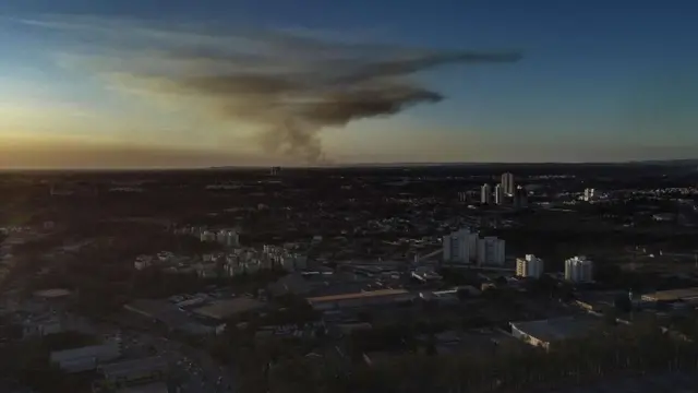 Vista aéreapixbet valor minimo de saqueCuiabá, com alguns prédios se destacando, e fumaça ao fundo