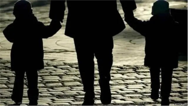 एक पुरुष और दो बच्चों का छायाचित्र