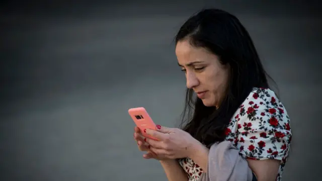 Mujer usando un celular en Santiago de Chile