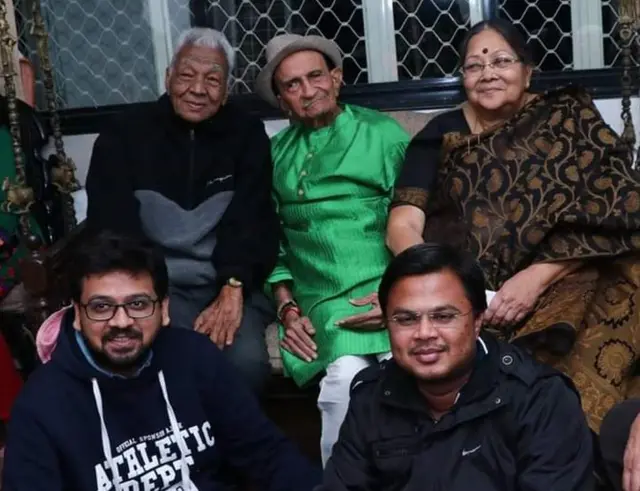 હાસ્યલેખક સ્વ. વિનોદ ભટ્ટ, ખૂબ પોપ્યુલર કોલમ 'દુનિયાને ઊંધા ચશ્માં' સિરિઝના સર્જક એવા સ્વ. તારક મહેતા અને હવે સ્વ. ઇન્દુ મહેતા અને નીચે બેઠેલા યુવા વાચકમિત્રો ડાબે ઈશાન ભાવસાર અને જમણે વિશાલ પટેલ. (તારક મહેતાના છેલ્લા જન્મદિને લીધેલી તસ્વીર, 26 ડિસેમ્બર, 2016)