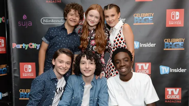 Actores de Stranger Things: (de pie, de izquierda a derecha) Gaten Matarazzo, Sadie Sink y Millie Bobby Brown; (sentados, de izquierda a derecha) Noah Schnapp, Finn Wolfhard y Caleb McLaughlin.