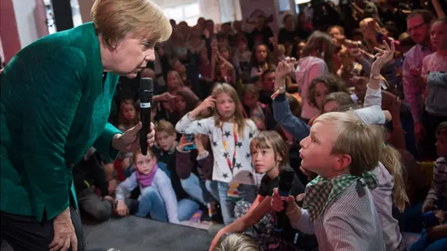 German Chancellor Angela Merkel dey talk with children