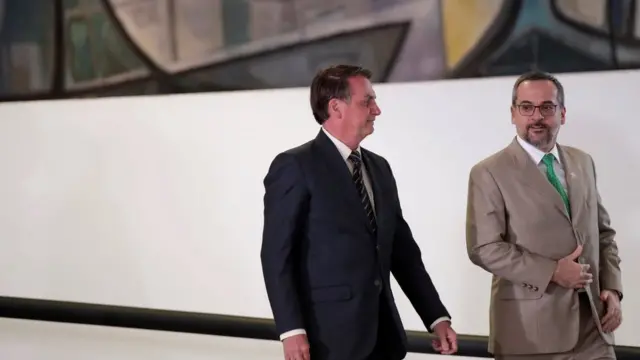 Jair Bolsonaro e2 0 beta hcgAbraham Weintraub sorriem enquanto conversam e descem rampa no Palácio do Planalto