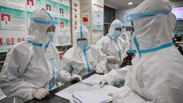 Medical staff members wearing protective clothing to help stop the spread of a deadly virus which began in the city, work at the Wuhan Red Cross Hospital in Wuhan on January 25, 2020.