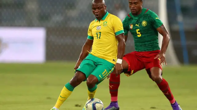 Tokelo Rantie (G) d'Afrique du Sud défié par le Camerounais Adolphe Kamgang lors du match de qualification de la CAN 2017 au stade Moses Mabhida, le 29 mars 2016, à Durban.