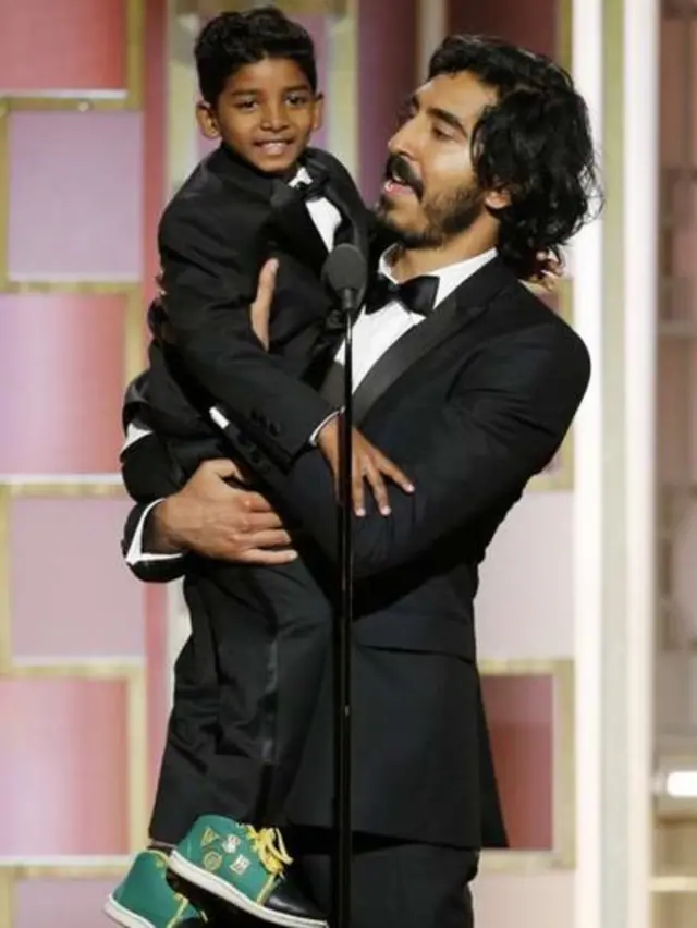 Dev Patel (phải) giúp bạn diễn nhỏ tuổi trong phim Lion Sunny Pawar lên vừa tầm microphone.