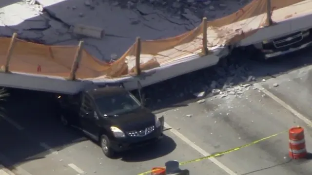 垮塌的桥压住了公路上的车。