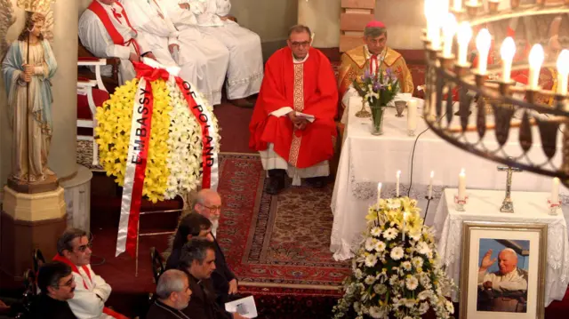 چند کشیش در کنار تصویر پاپ فقید ژان پل دوم در کلیسایی در تهران در آوریل ۲۰۰۵.
