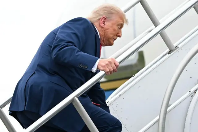 Le président américain Donald Trump trébuche alors qu'il monte à bord d'Air Force One avant son départ de l'aéroport municipal de Morristown, dans le New Jersey, le 8 juin 2025, en route pour Camp David.